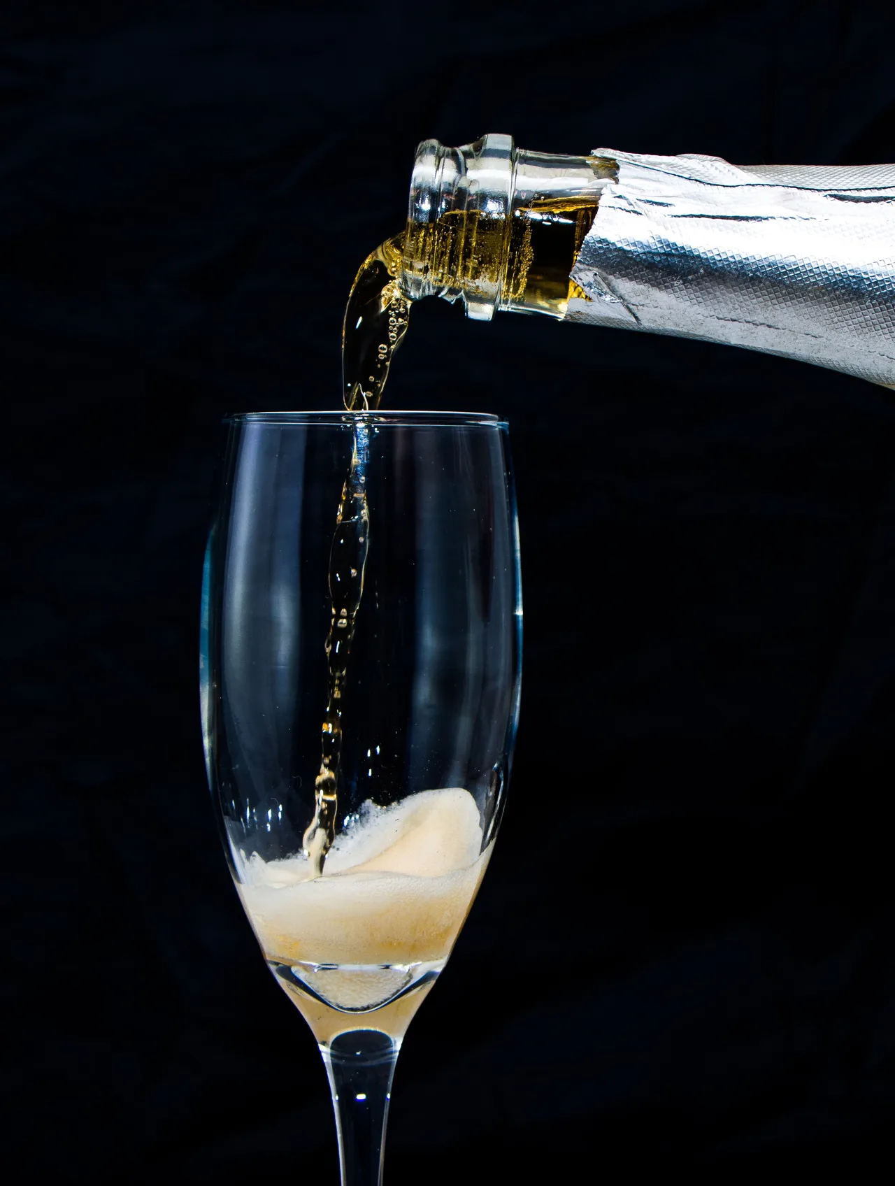 Champagne being poured into a glass against a midnight backdrop